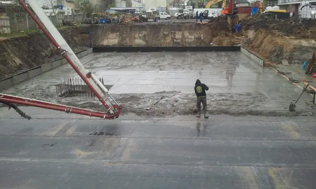 Świeżo wylana płyta betonowa lśni wilgocią zaraz po zakończeniu betonowania fundamentu