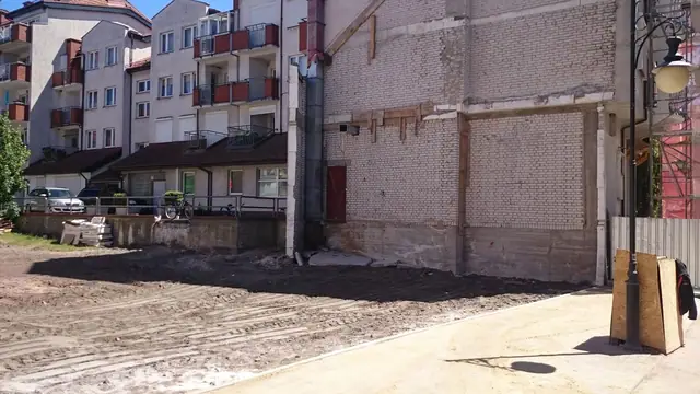 Uporządkowany teren po rozbiórce przy ulicy Cichej z zachowaną ścianą i latarnią