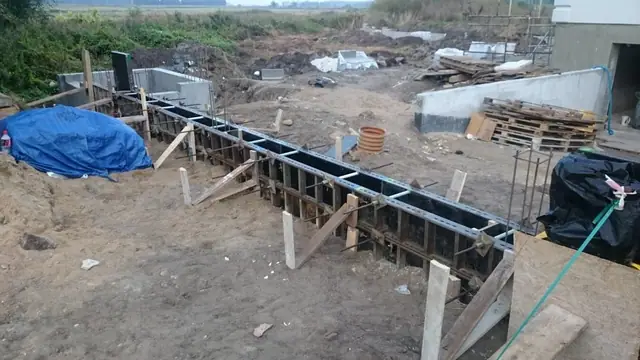Wykop i drewniany szalunek pod fundament tarasu na piaszczystym placu budowy domu koło Kołobrzegu