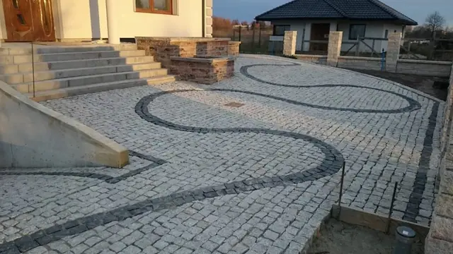 Perspektywa ze schodów na esowaty wzór kostki brukowej na podwórku domu
