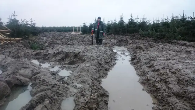 Głęboki, zalany wodą wykop w gliniastym gruncie na terenie plantacji w Rogozinie