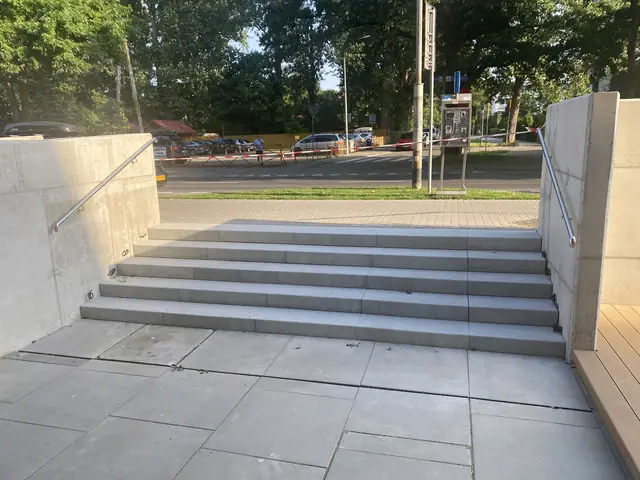 Gotowe betonowe schody zewnętrzne z otynkowanymi murkami prowadzące od strony ulicy