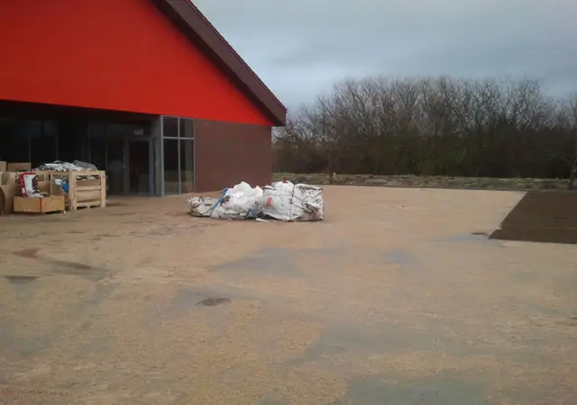 Uprzątnięty plac przed wejściem do marketu z workami po materiałach budowlanych