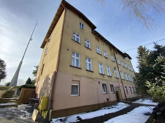 Elewacja budynku ośrodka Jantar w Dźwirzynie z anteną na dachu i śniegiem na chodniku przed rozbiórką