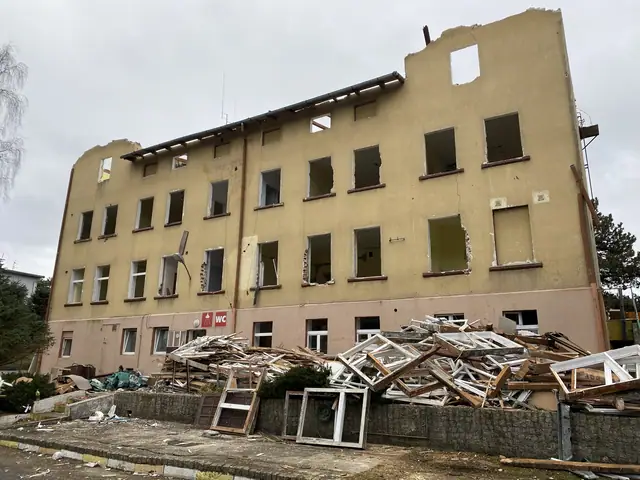 Front budynku ośrodka Jantar po częściowej rozbiórce dachu, wybite okna i gruz przed elewacją