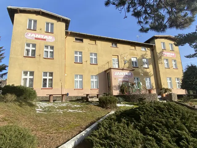 Front budynku ośrodka wypoczynkowego Jantar w Dźwirzynie z szyldem firmowym przed rozpoczęciem rozbiórki