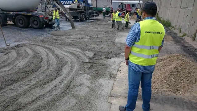 Pracownik SZYMETA nadzoruje wylewkę betonu na placu składowym Miejskiej Energetyki