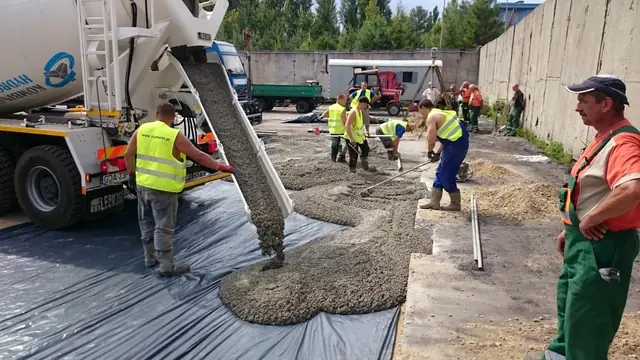 Pompa do betonu wylewa mieszankę, ekipa rozprowadza ją na placu składowym MEC