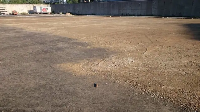 Żwirowy plac przygotowany pod nawierzchnię betonową przy murze oporowym MEC