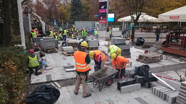 Drewniana ławka na ukończonym placu przy molo w Kołobrzegu widziana o zmierzchu