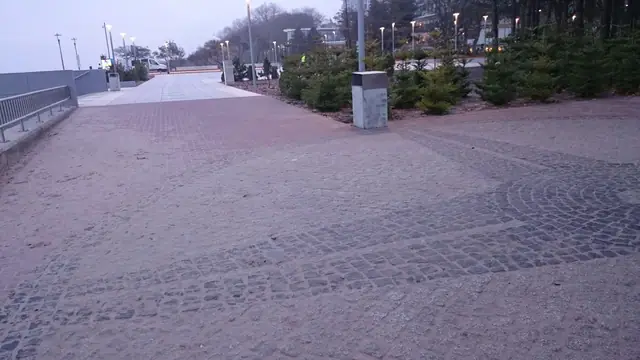 Kamienna nawierzchnia w promienistym wzorze przy schodach na promenadzie przy molo w Kołobrzegu wieczorem