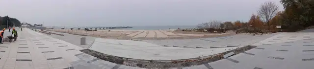 Widok wzdłuż nowo ułożonych płyt chodnikowych na plaży w kierunku morza przy molo w Kołobrzegu