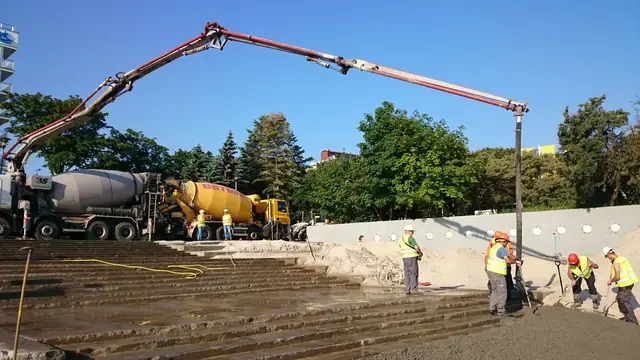Pompa do betonu i betoniarka zalewają fundament nowej konstrukcji nad brzegiem morza przy molo w Kołobrzegu