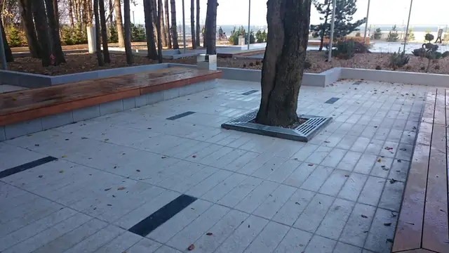 Promienisty wzór kamiennej nawierzchni przy schodach na promenadzie przy molo w Kołobrzegu, zapalone latarnie
