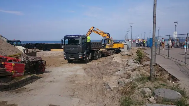 Samochód ciężarowy z dźwigiem HDS stoi na placu budowy promenady przy molo w Kołobrzegu