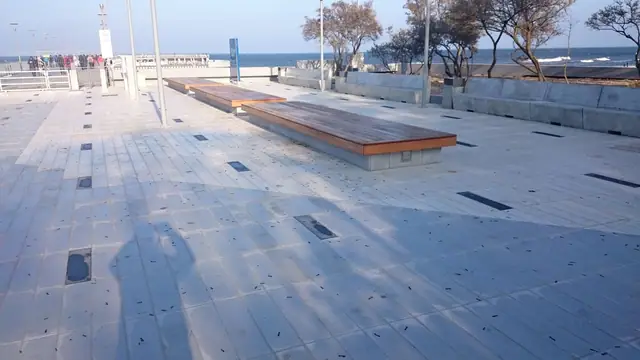 Ścieżka spacerowa wzdłuż nasadzeń zieleni na promenadzie przy molo w Kołobrzegu widziana wieczorem