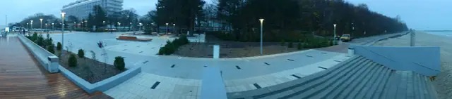 Szeroka promenada spacerowa wzdłuż wybrzeża przy molo w Kołobrzegu po zmroku