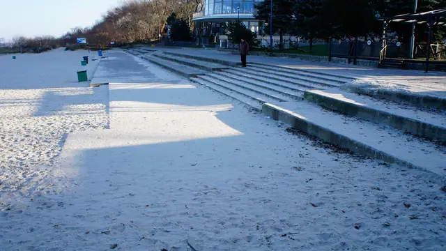Zaśnieżone betonowe schody prowadzące na plażę przy molo w Kołobrzegu w stanie sprzed remontu