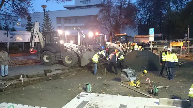 Zbliżenie na wzór jasnych i ciemnych płyt ukończonego placu przy molo w Kołobrzegu, widoczne włazy rewizyjne