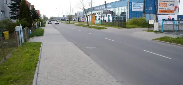Wybrukowany chodnik wzdłuż ukończonej drogi przy zabudowie przemysłowej ulicy Jasnej