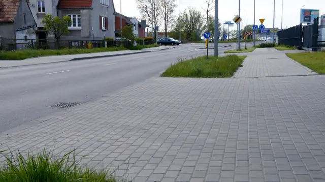 Wykończone skrzyżowanie z nową nawierzchnią i oznakowaniem przy wjeździe na rondo