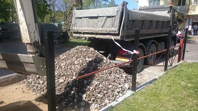 Ciężarówka wysypuje kruszywo na podbudowę remontowanej drogi wewnętrznej