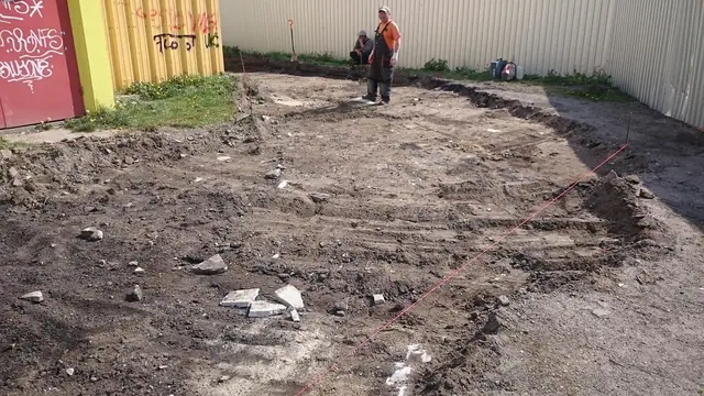Pracownicy wytyczają sznurkiem przebieg nowej nawierzchni na wyrównanym gruncie