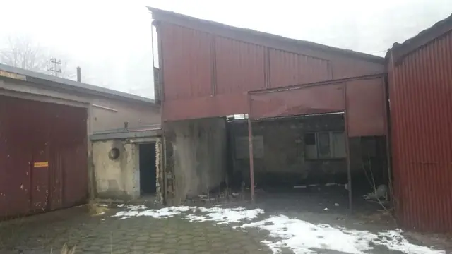 Częściowo zawalony dach blaszany odsłaniający wnętrze dawnego podwórza bazy PKS