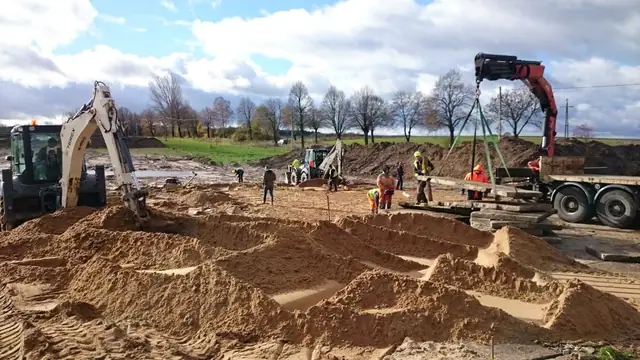 Dźwig ustawia prefabrykowane elementy betonowe na placu w trakcie budowy