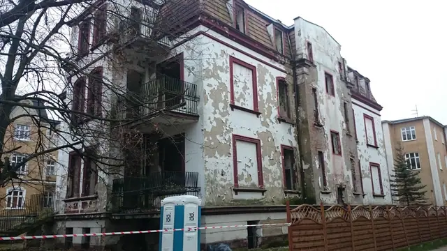 Tylna elewacja zabytkowej willi z balkonami i odpadającym tynkiem przed rozbiórką