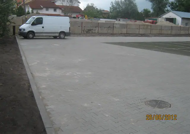 Parking z kostki betonowej z zaparkowanym busem przy murze oporowym