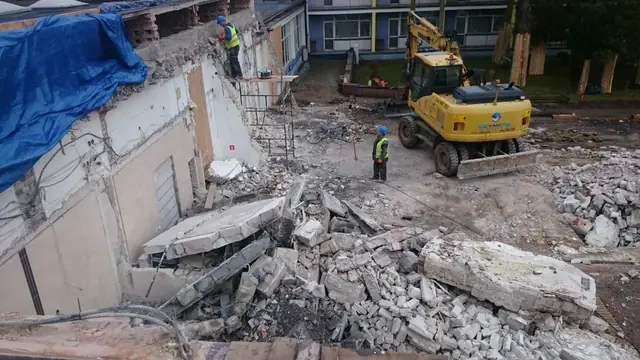 Koparka rozbiera ścianę budynku, gruz zalega na ziemi przy Centrum Verano w Kołobrzegu