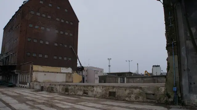 Boczny widok pustego spichlerza na rozległym betonowym placu portu