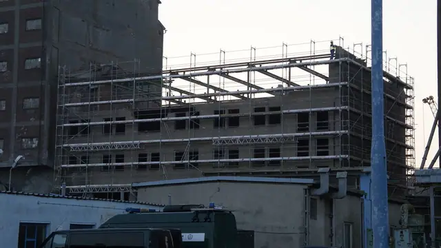 Wielopiętrowy budynek w rusztowaniu przygotowany do rozbiórki na terenie portu