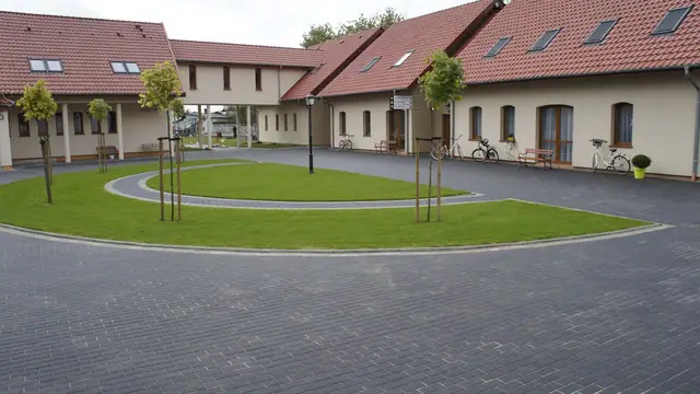 Elewacja budynku Domu Pielgrzyma z wybrukowanym placem przed wejściem