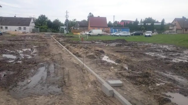 Ustawiony krawężnik wyznacza przebieg przyszłej alejki na rozmokłym terenie w Skrzatuszu