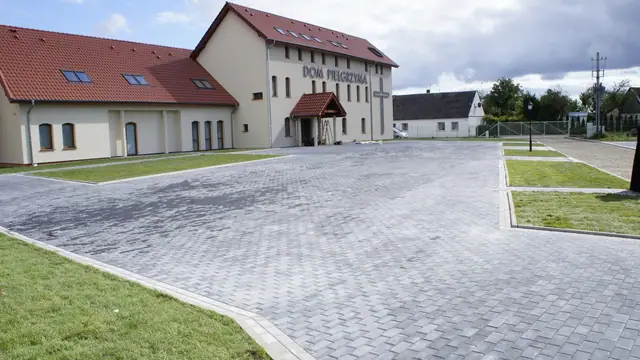 Gotowy plac łączący nawierzchnię żwirową i trawiaste kwatery przy zabudowaniach sanktuarium