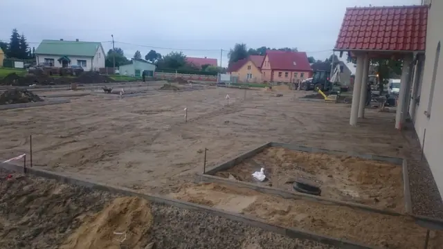 Wytyczony obrys przyszłego placu na piaszczystym terenie przed budynkiem sanktuarium