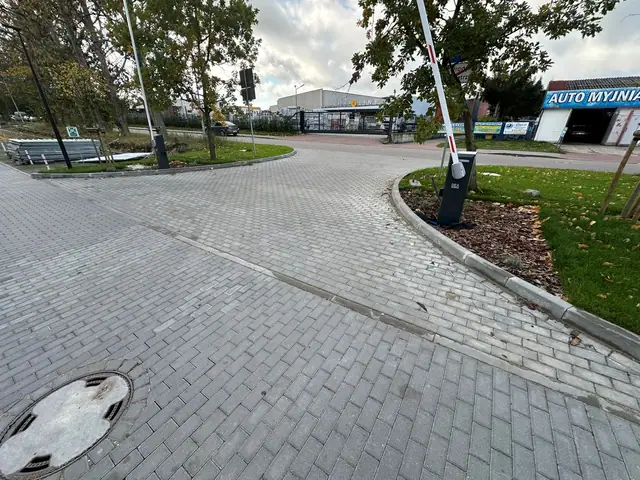 Rondo z kostki brukowej z klombem i włazem kanalizacyjnym na skwerze osiedlowym
