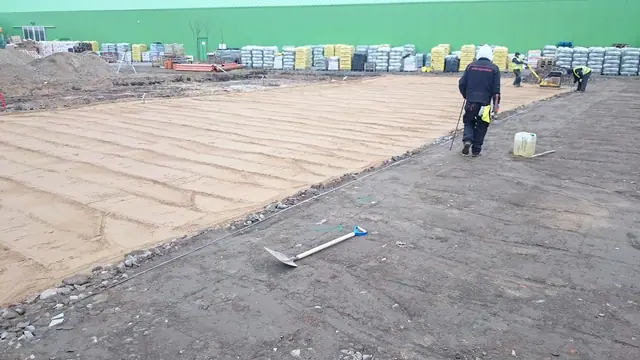 Pracownik sprawdza wyrównane podłoże przed centrum ogrodniczym Żulicki
